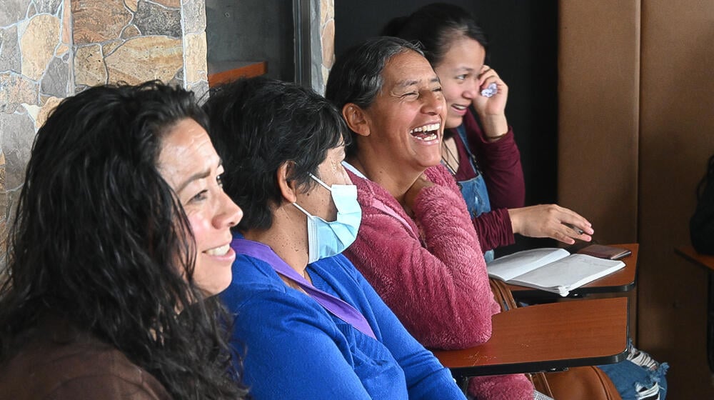 foto de cuatro mujeres sentadas, una de ella ríe